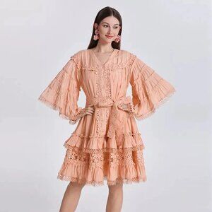 Vestido A mid-length elegant dress in orange with ruffles and embroidery